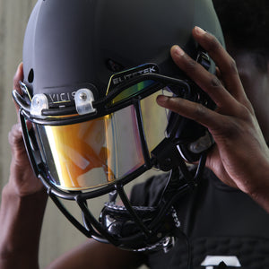 Athelete wearing Elitetek Compression Shirt while putting on black helmet with Orange Visor